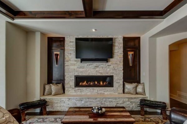 basement remodel with stone wall fireplace and home theater