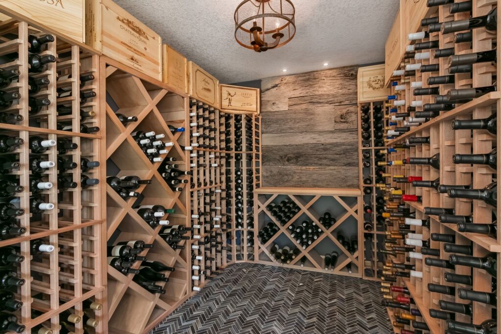 Luxury wine cellar with custom wood racks, herringbone tile flooring, and rustic wood accent wall