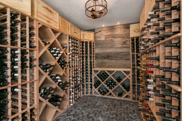 Luxury wine cellar with custom wood racks, herringbone tile flooring, and rustic wood accent wall