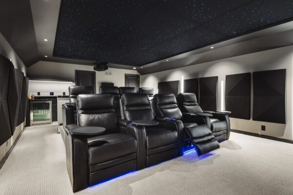 Home theater room with leather recliners, acoustic panels, and star ceiling lighting