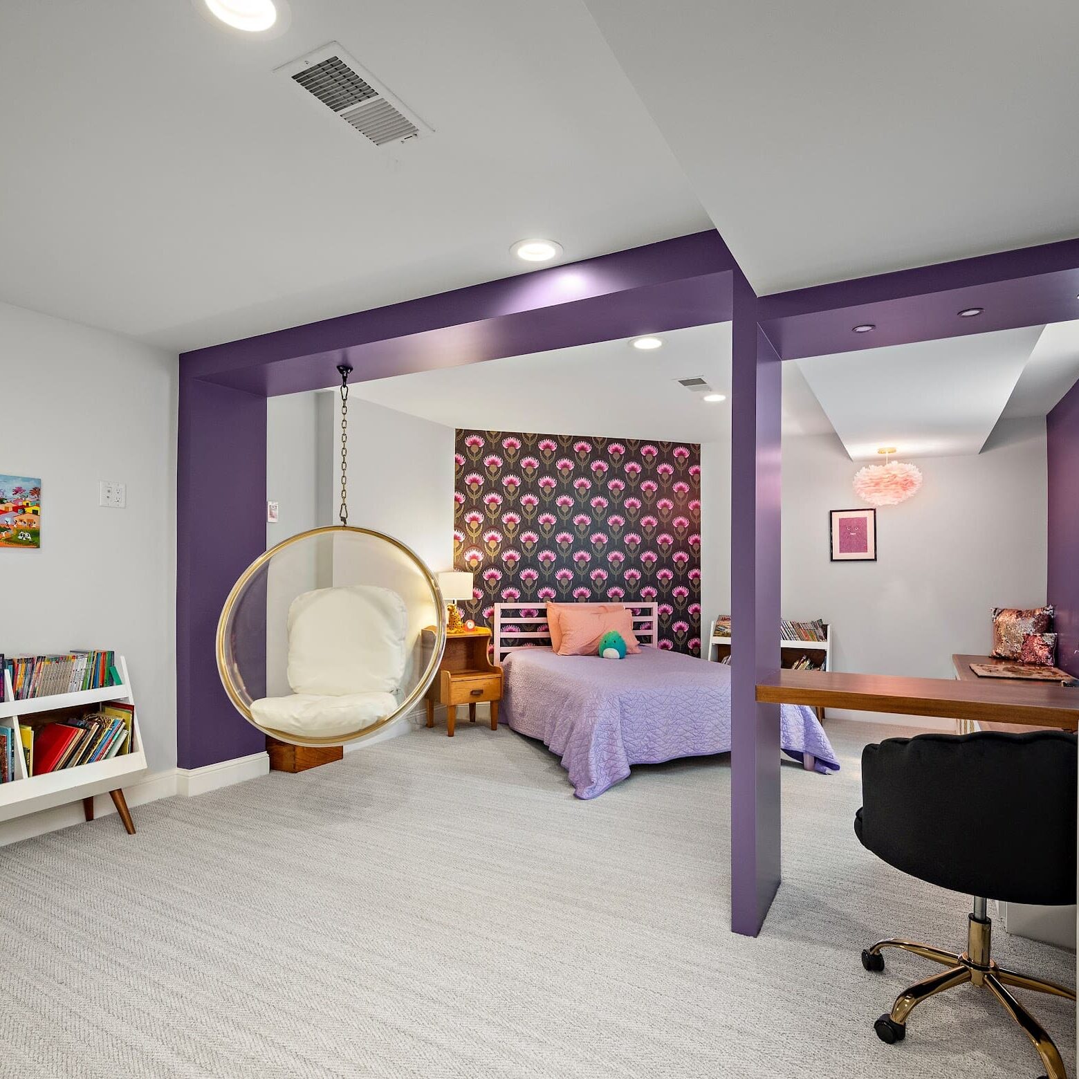 Colorful kids’ bedroom with purple built-in framing, swing chair, and patterned feature wall