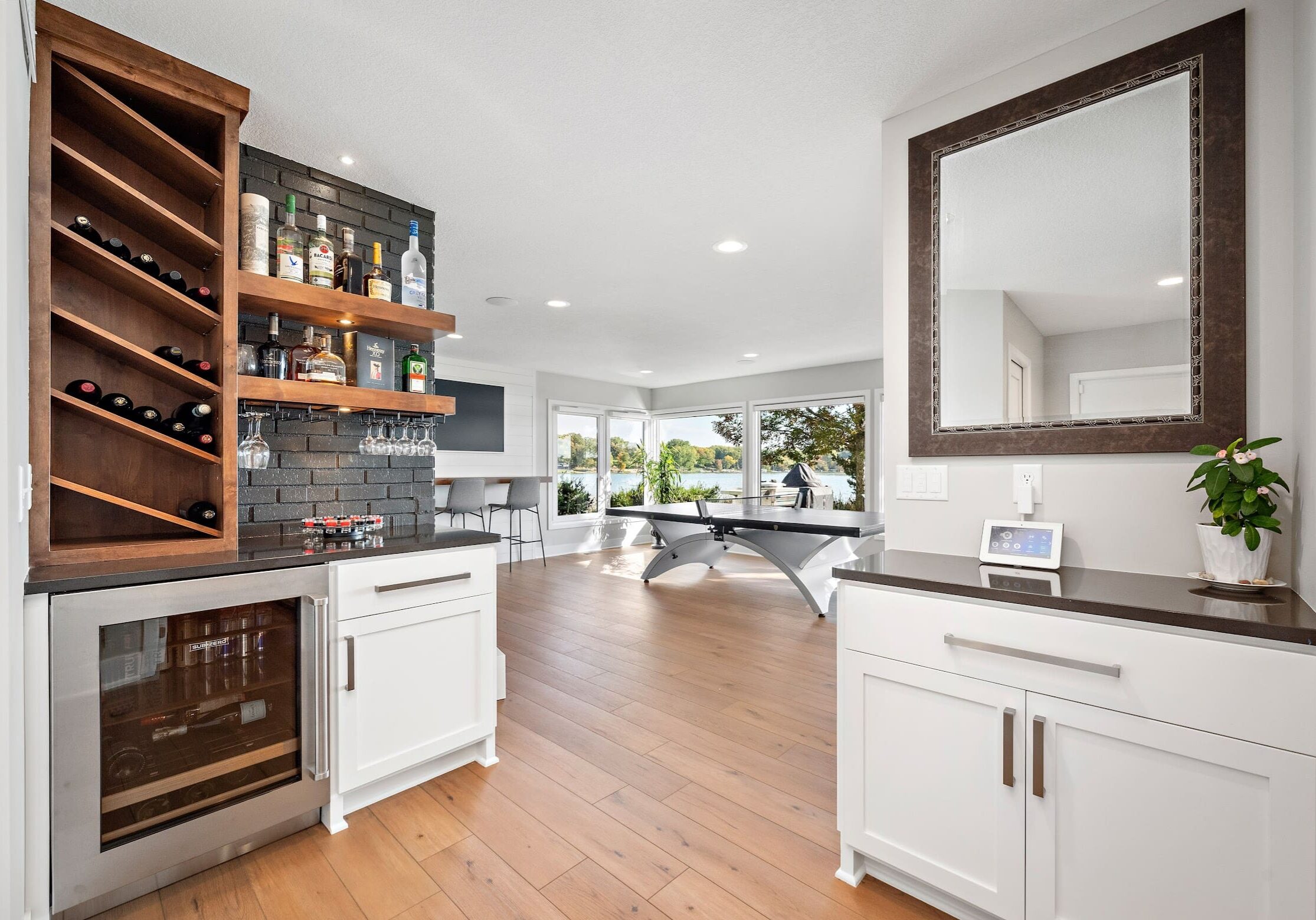 Basement bar and entertainment area with black brick, lake views, and ping pong table